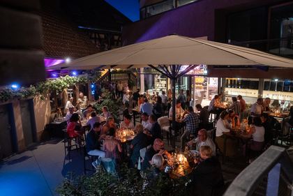 Abendveranstaltung im Innenhof unter Sonnenschirmen