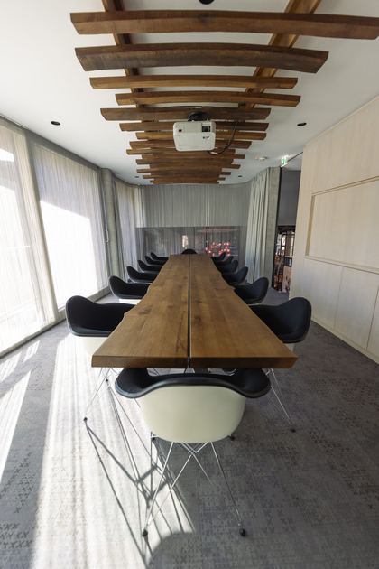 Besprechungszimmer mit langer Tafel und Holzdecke
