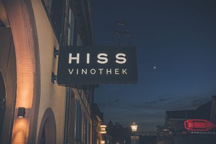 Der Leuchtschriftzug HISS Vinothek bei Nacht