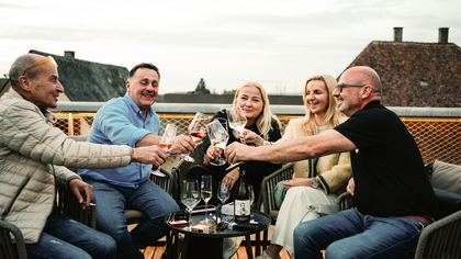 Gäste stoßen auf der Dachterrasse mit Wein an