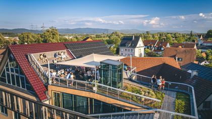 Gäste auf der Dachterrasse, dahinter die Dächer von Eichstetten