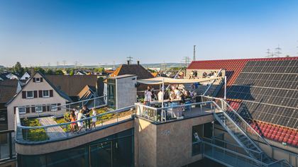 Gäste auf der Dachterrasse des Weinhauses unter dem Sonnensegel