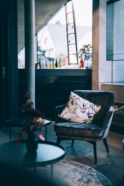 Sessel mit geblümtem Kissen und Beistelltisch in der Lounge