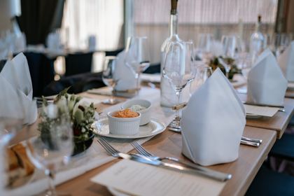 Gedeckte Festtafel mit Blumenschmuck und Menükarten