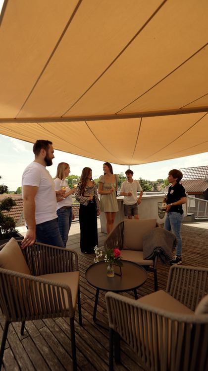 Gäste auf der Terrasse unter den Sonnensegeln